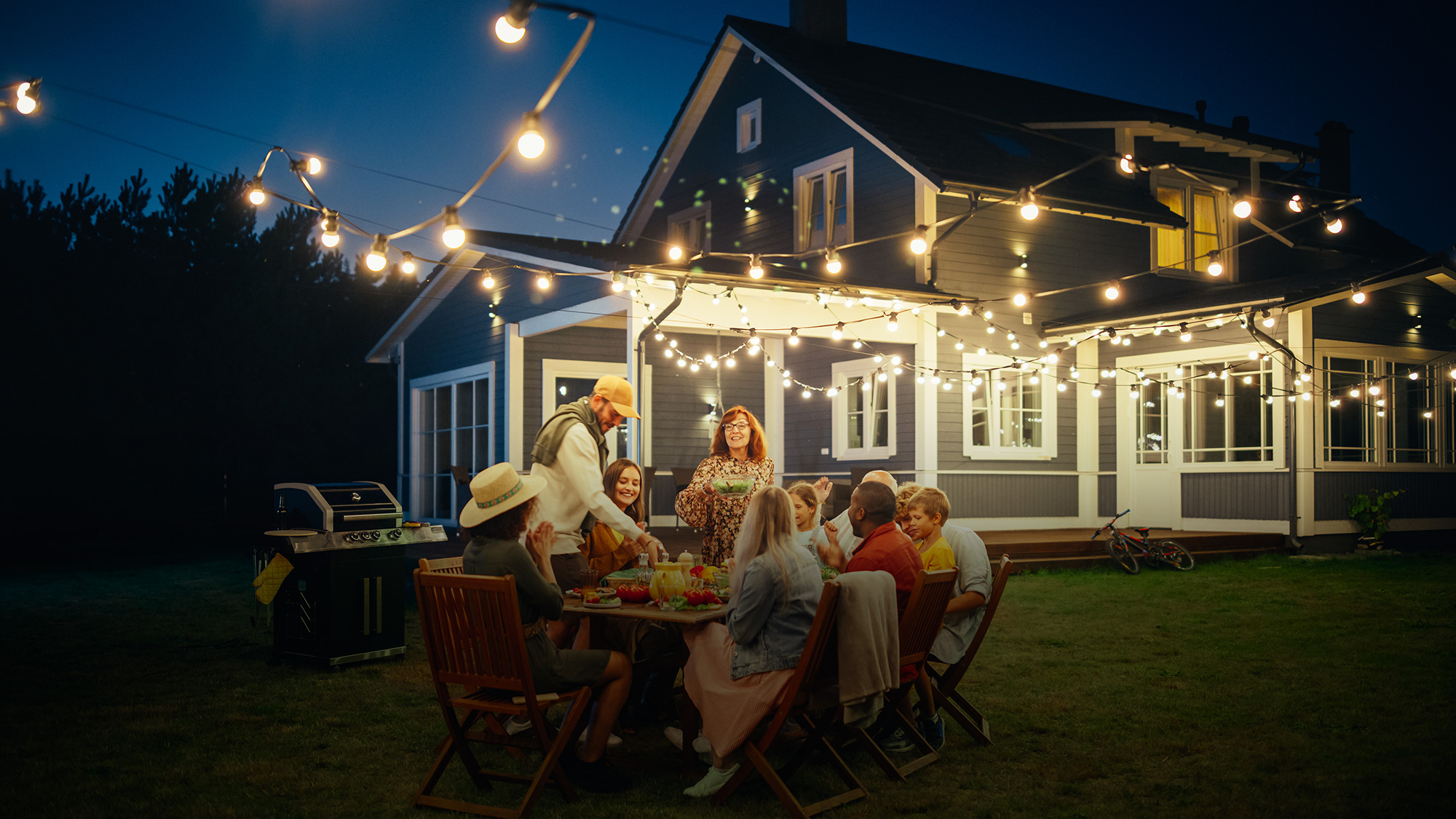 Home Insurance Family Dinner Outside home with lights slider image